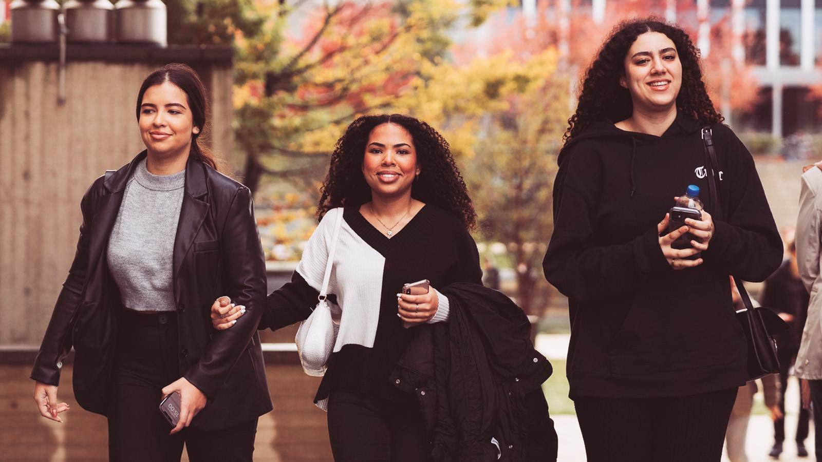 Drie studenten die over de campus lopen