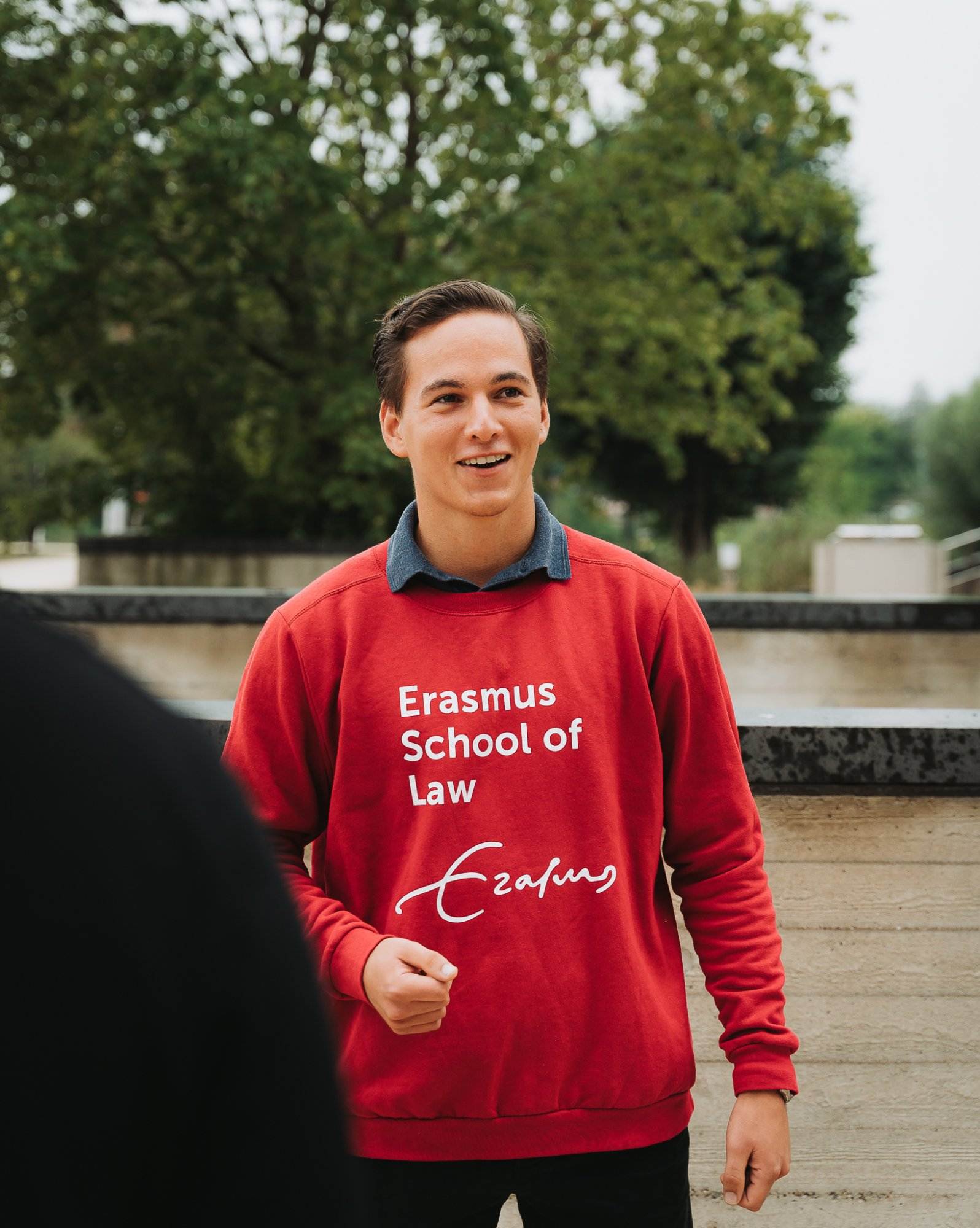 Jongen met rode trui met het logo van Erasmus School of Law als opdruk